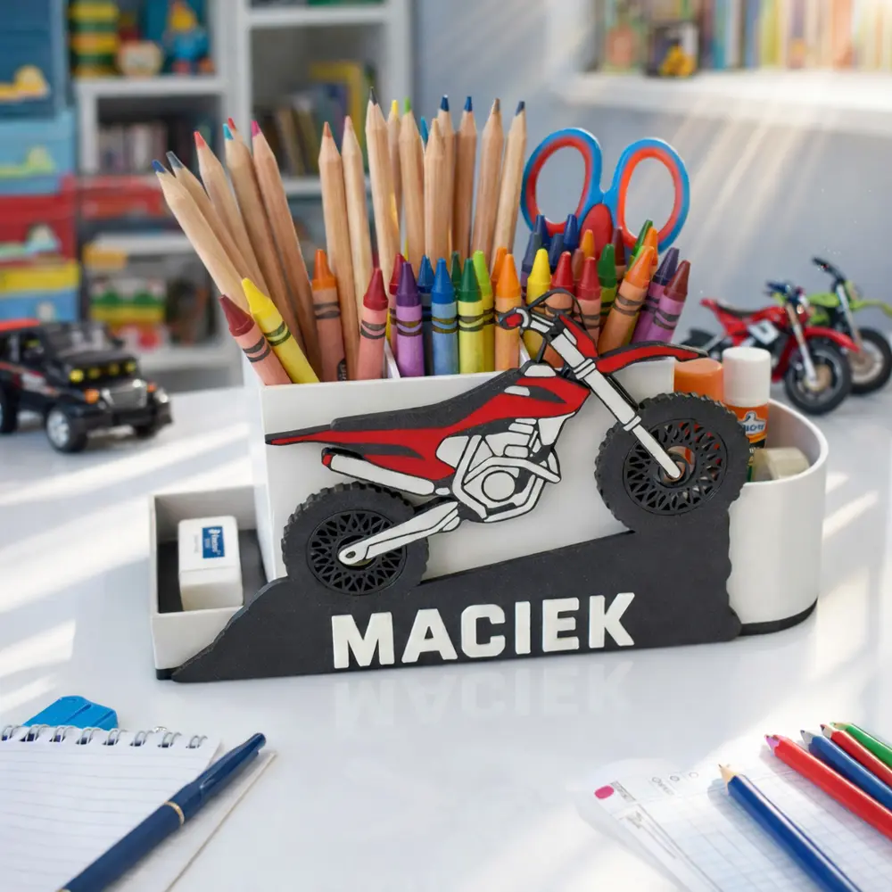 Organizer na biurko z motorem cross ustawiony w pokoju dziecięcym na blacie. Praktyczny pojemnik pomaga utrzymać porządek wśród szkolnych przyborów chłopca.