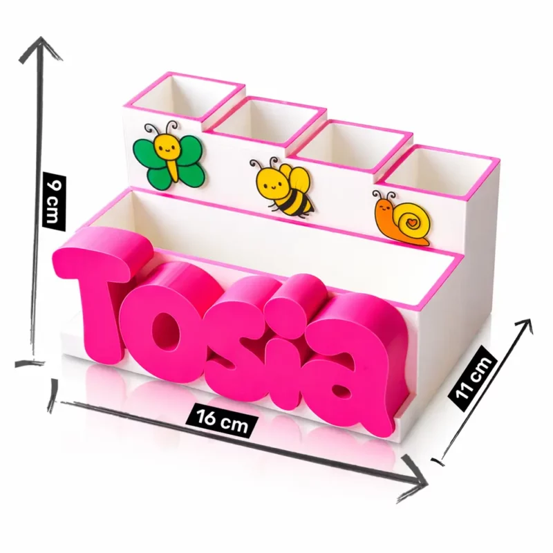 Grafika techniczna prezentująca dokładne wymiary białego organizera na biurko dla dziewczynki z motywem owadów i imieniem Tosia. Czarne strzałki wskazują, że szerokość całkowita przybornika to 16 centymetrów, głębokość wynosi 11 centymetrów, a jego wysokość w najwyższym punkcie z tyłu sięga 9 centymetrów.